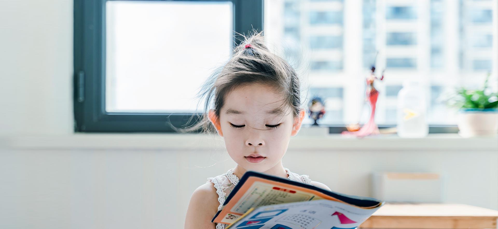 Young girl reading a book in class.