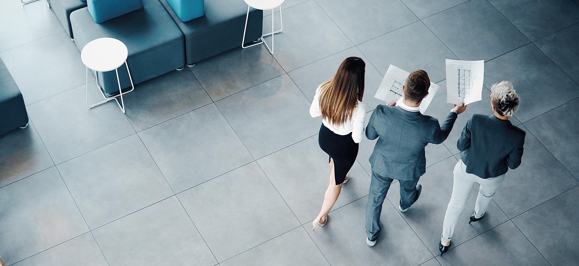 Three college managers walk and talk.