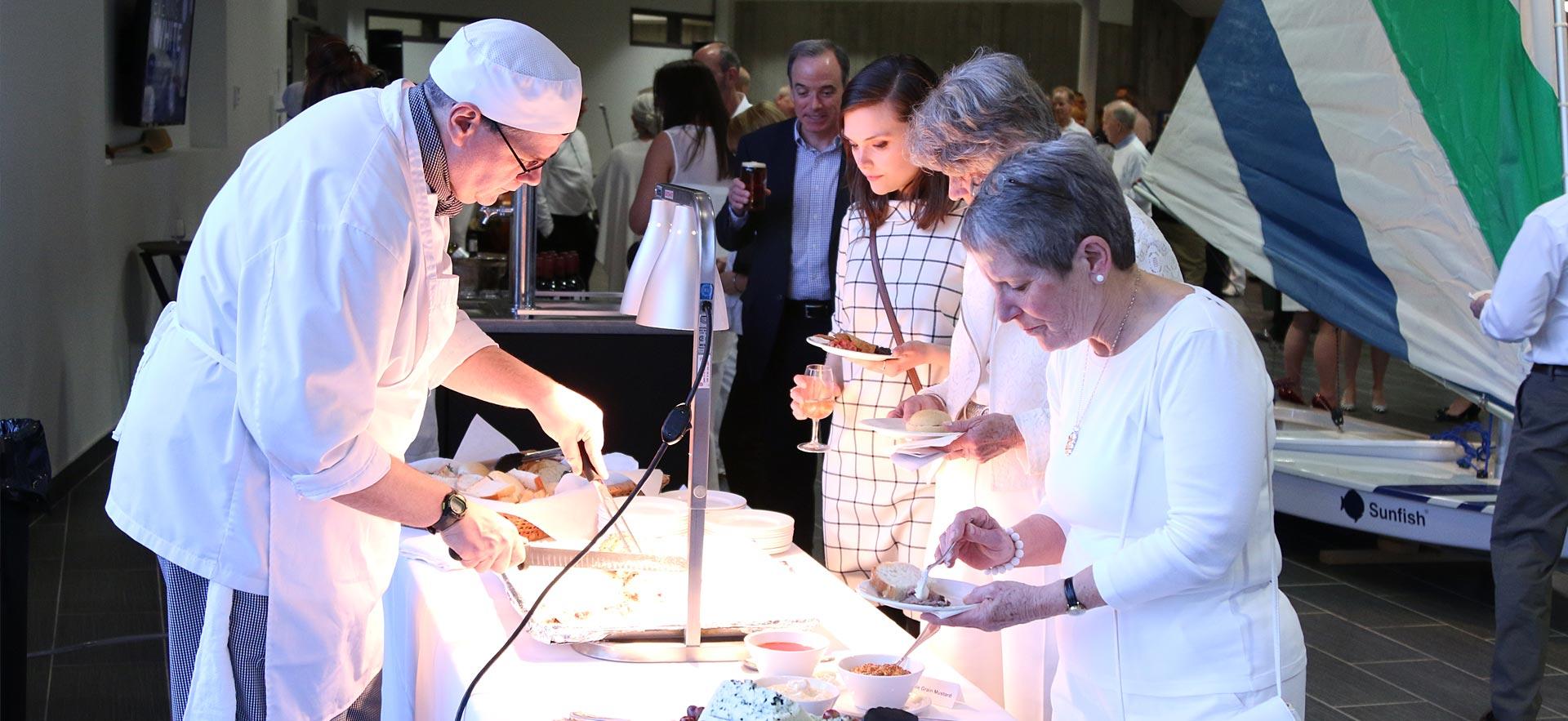 A male culinary student prepares food for participants at a Sault College event.