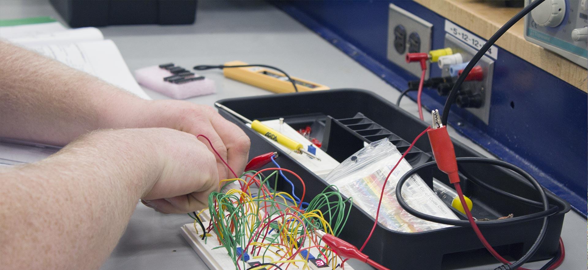 One male Electrical Engineering student working on an in class assignment.