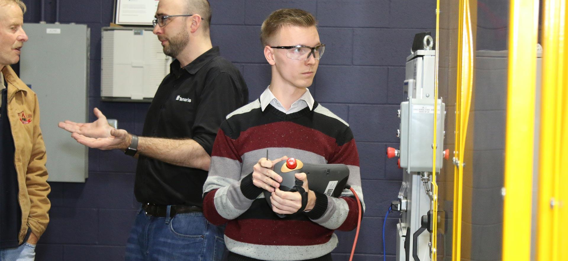 One male Electrical Engineering student demonstrating an automated project.