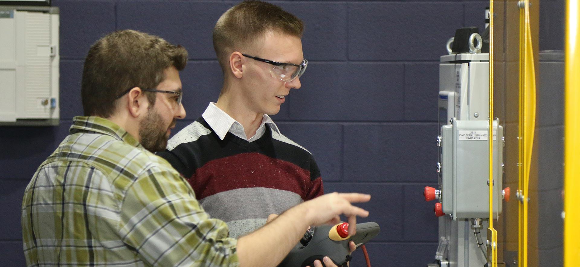 Two male Electrical Engineering students demonstrating an automated project.