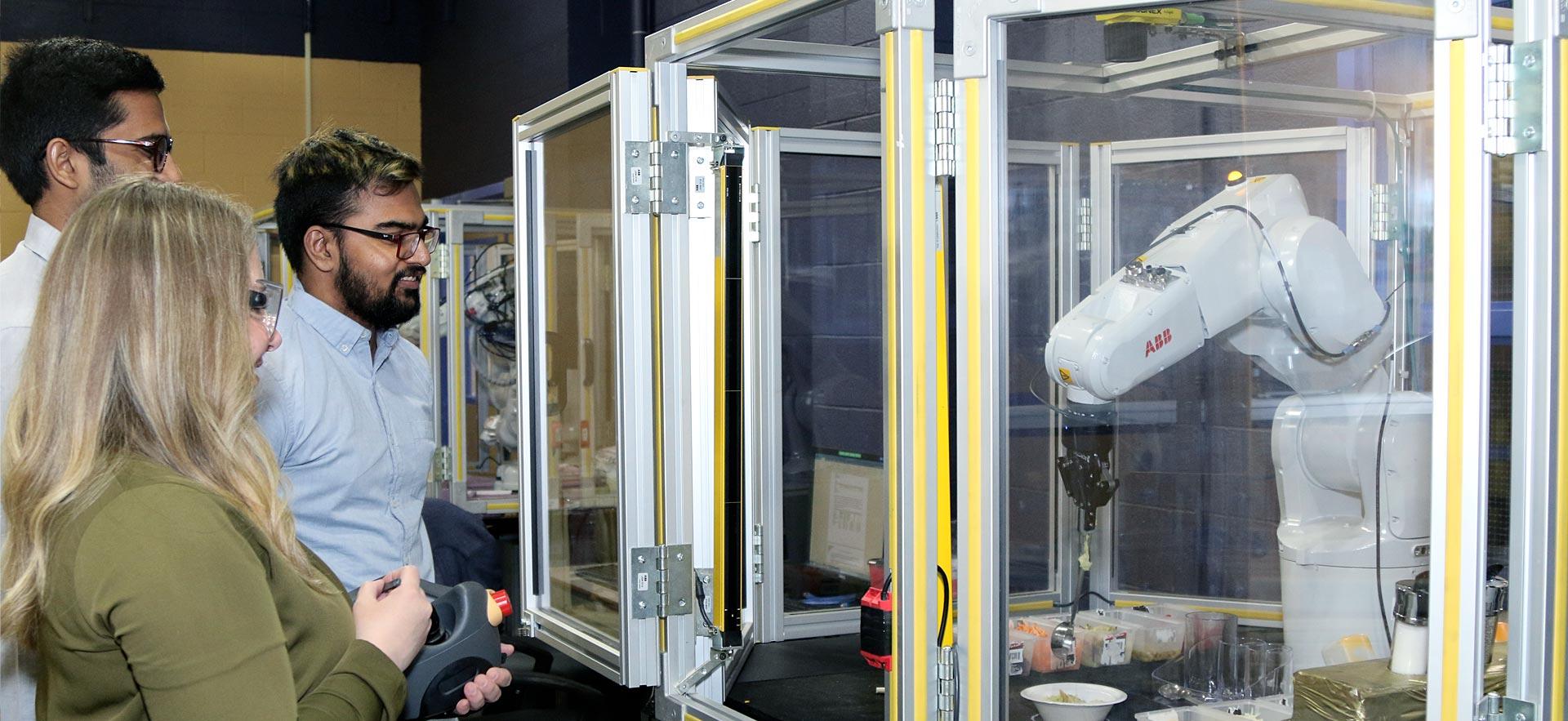 Two male Electrical Engineering students demonstrating an automated project.