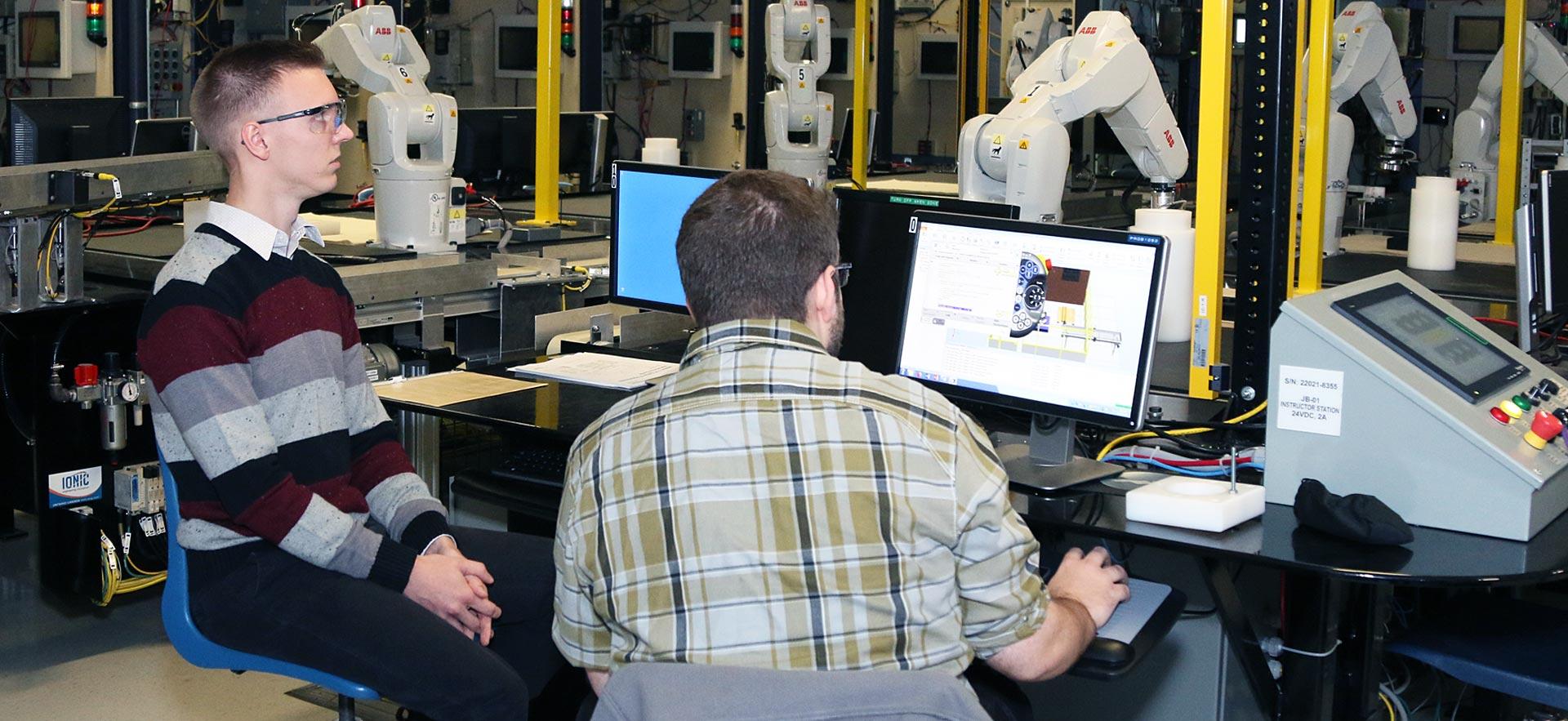 Two male Electrical Engineering students demonstrating an automated project.