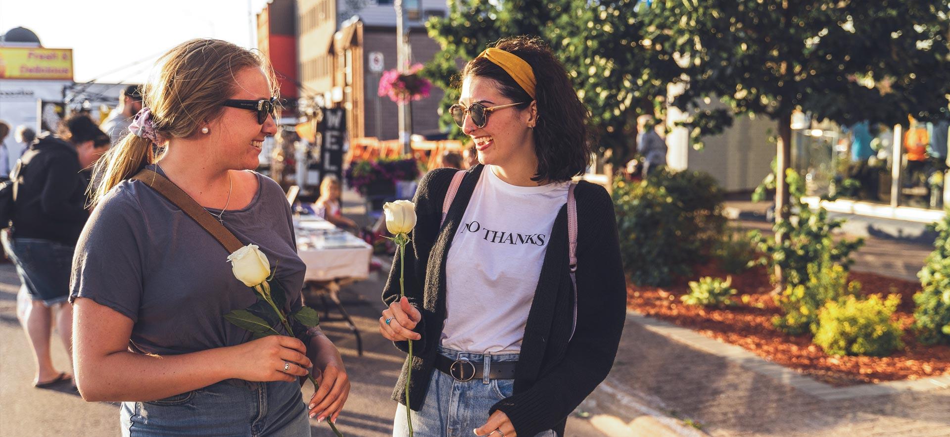 Two young women walking downtown during a festival.