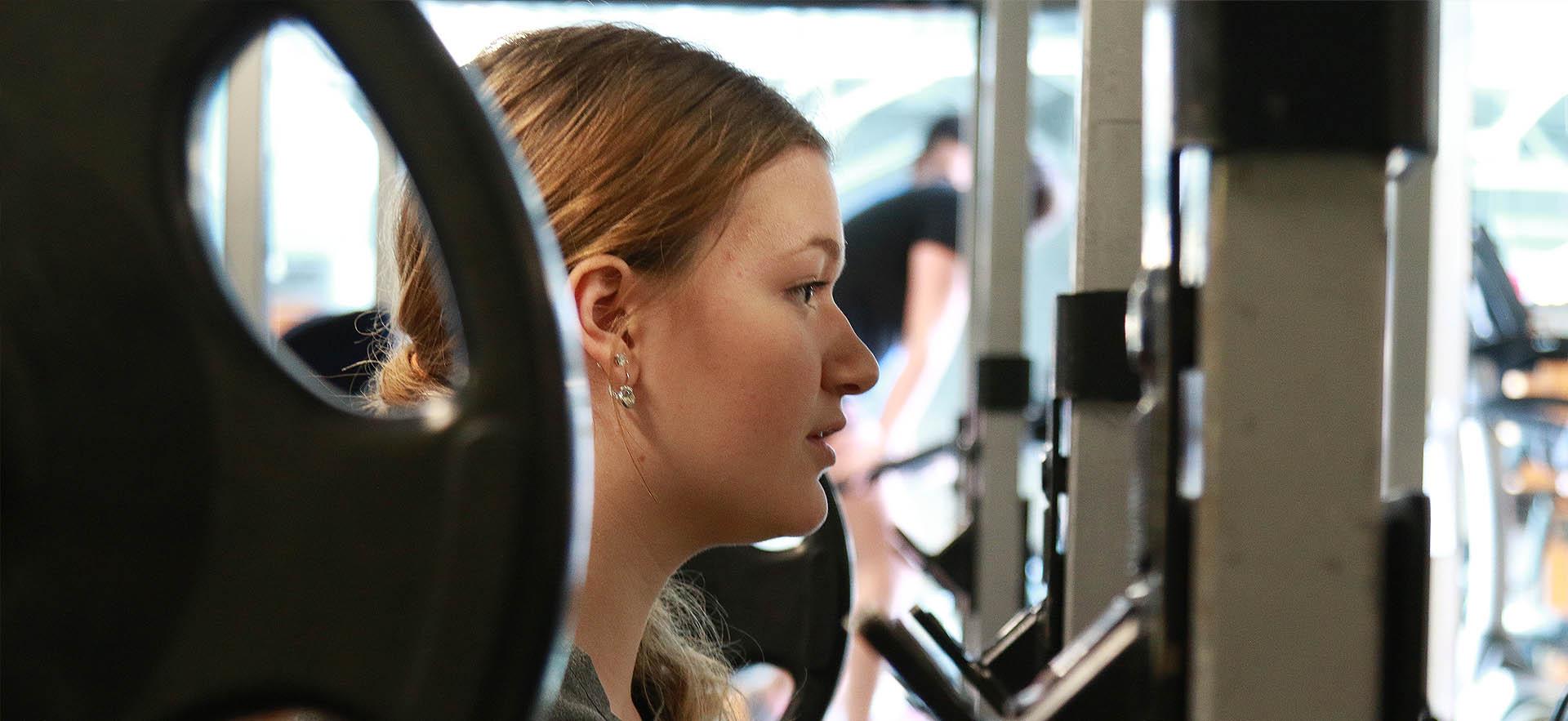 Student with barbell doing squat