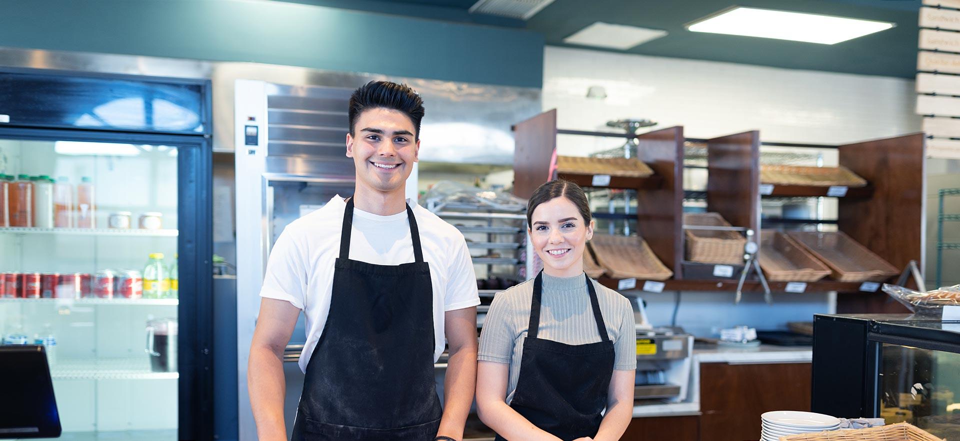 Smiling male and female food service worker.