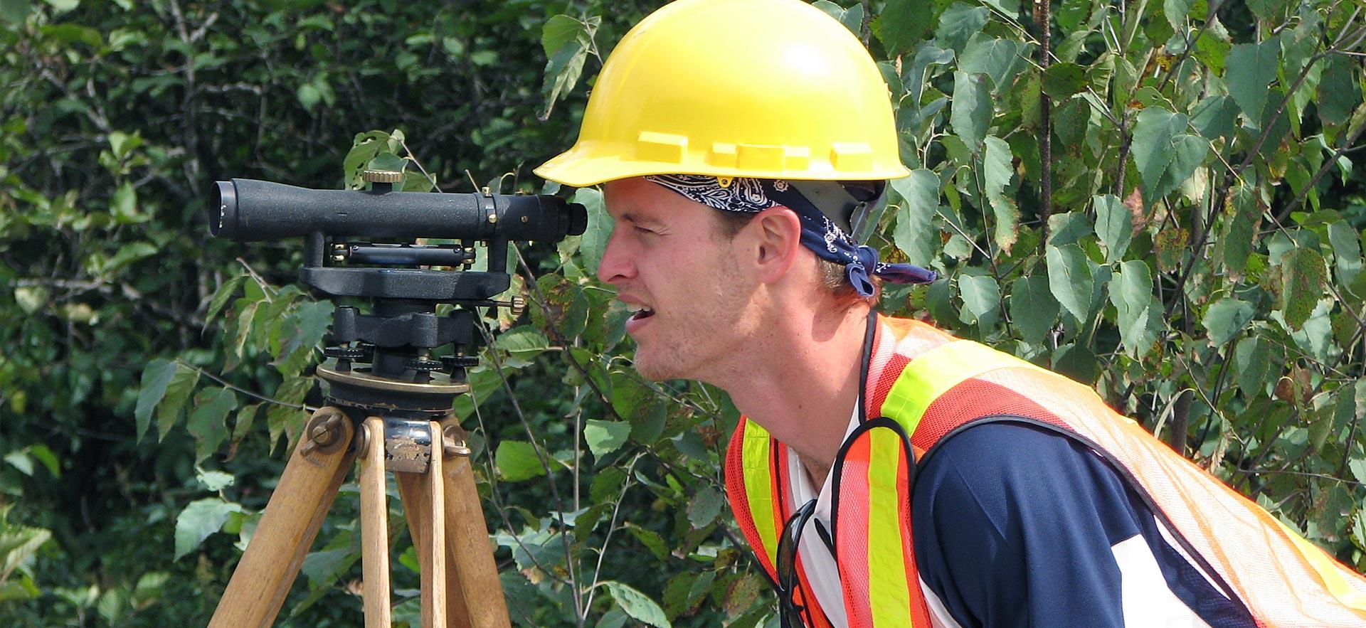 Male forestry conservation student surveys the forest he is in.