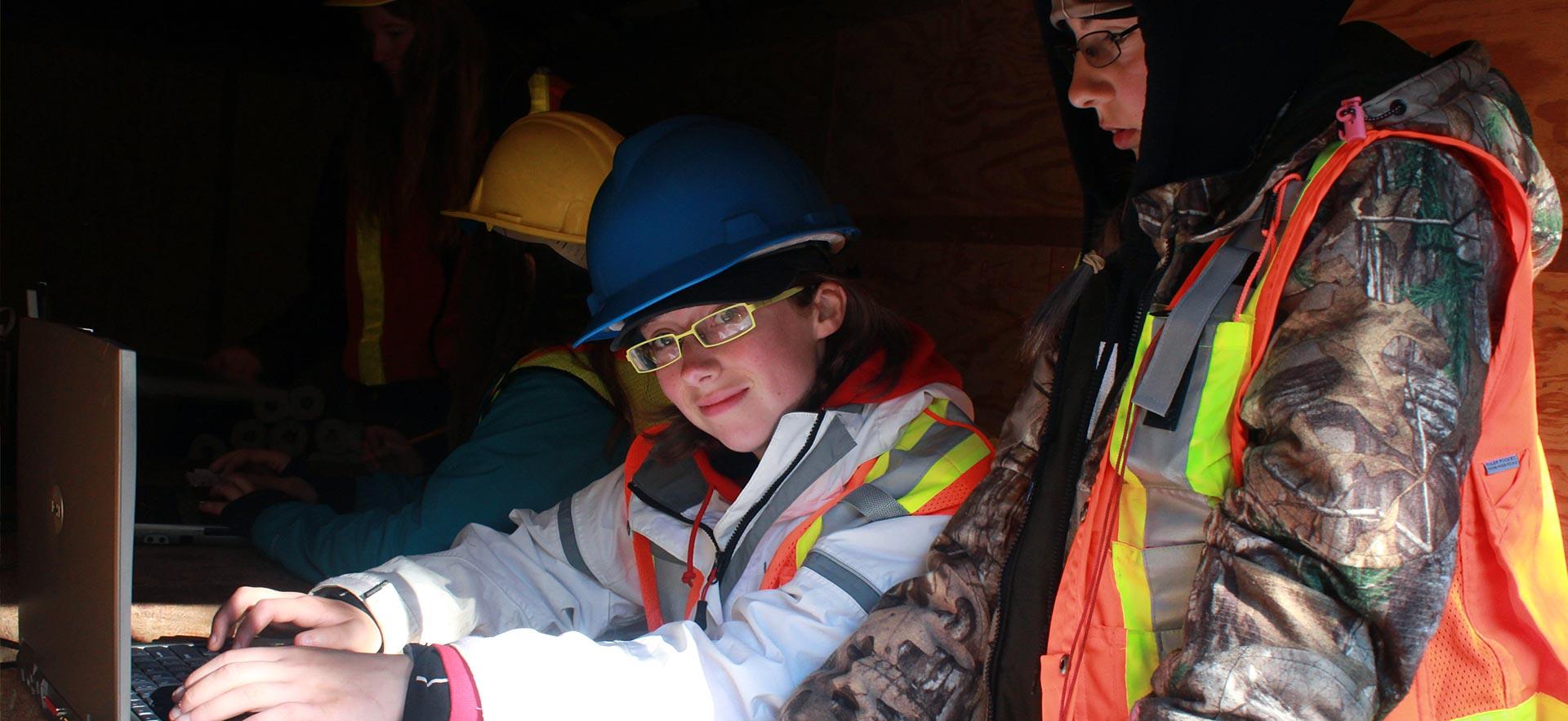 female forestry conservation works on her laptop during a field trip.