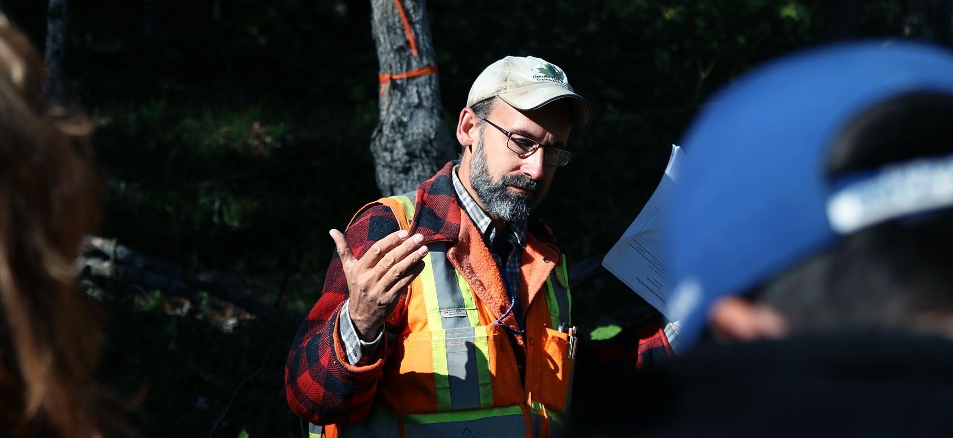 Male forestry conservation instructor teaches his class during field camp.