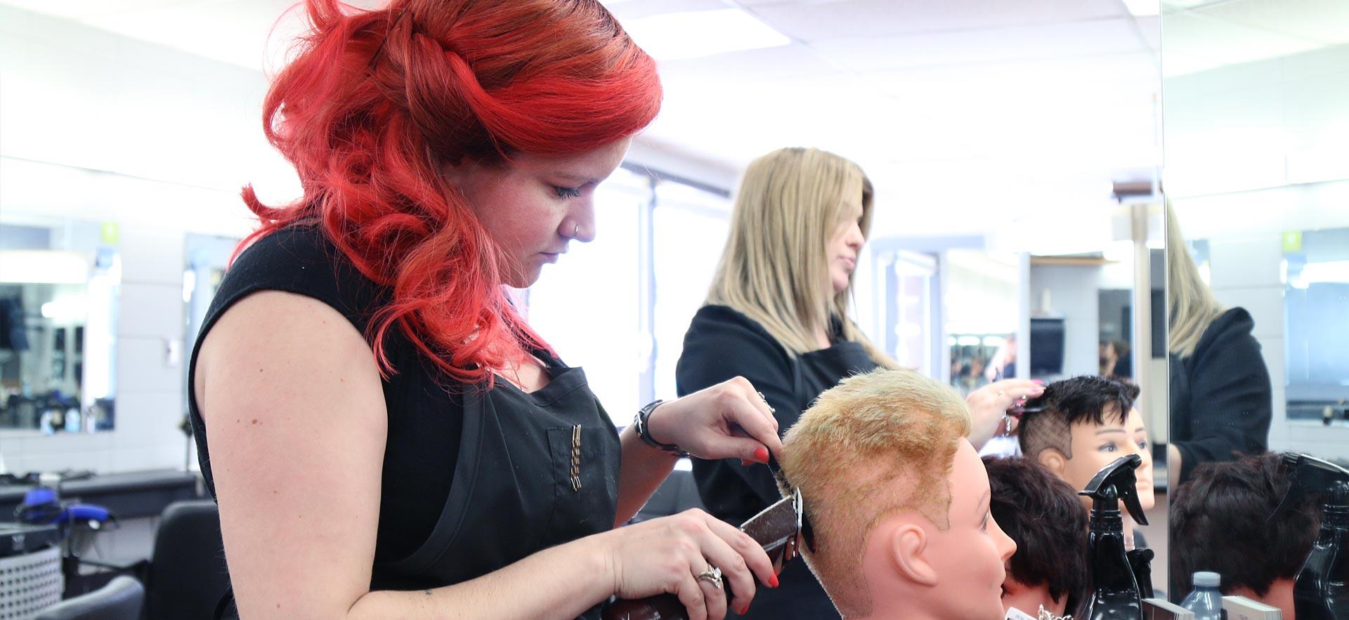 Female hairstylist student practices on a mannequin.