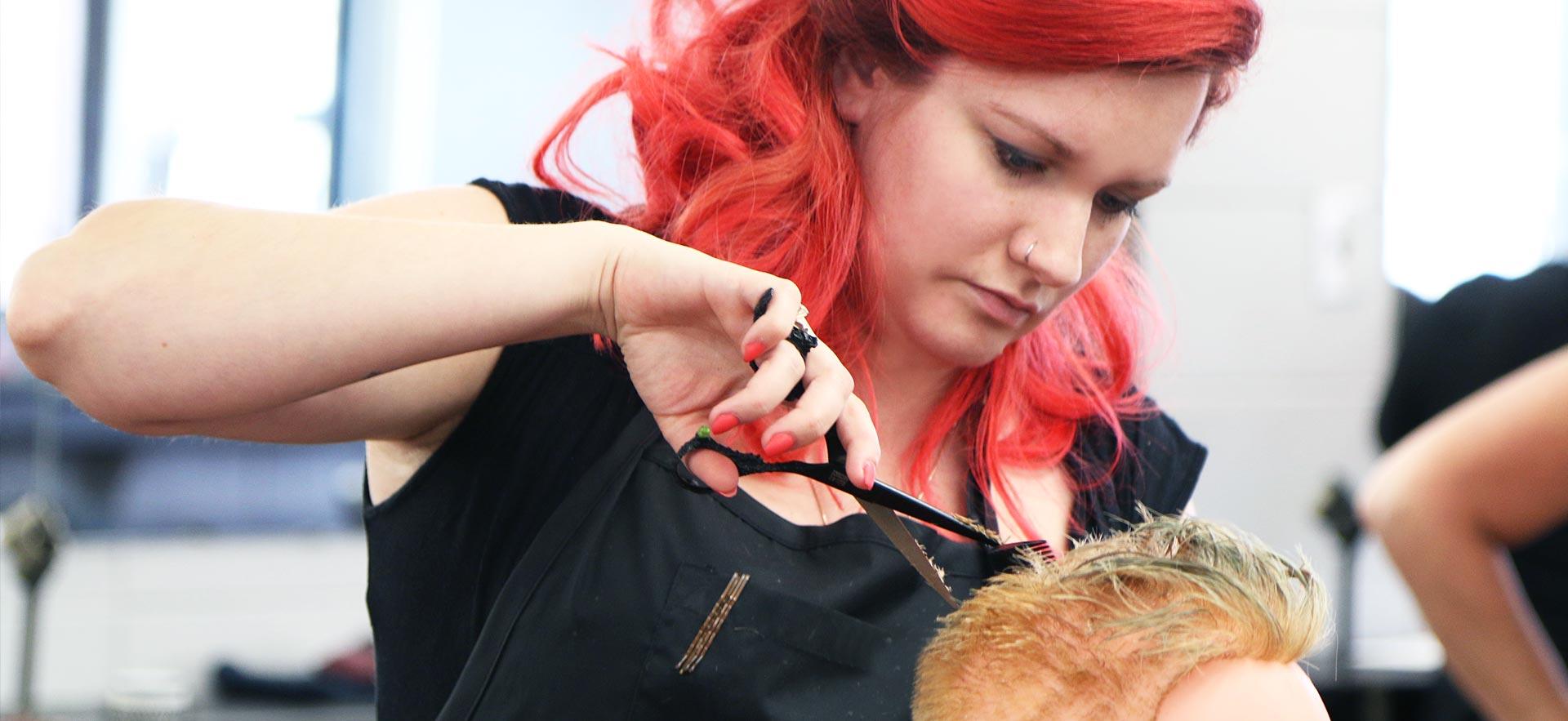 Female hairstylist student practices on a mannequin.