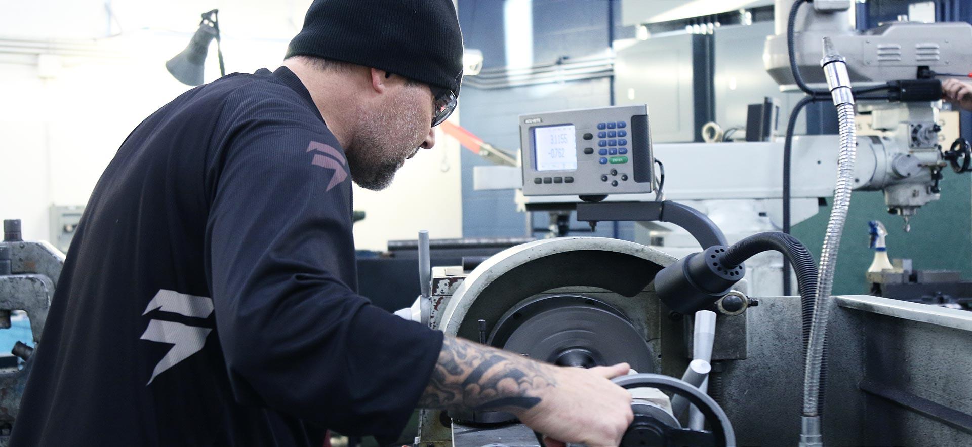 One male machine shop student working on a class project.