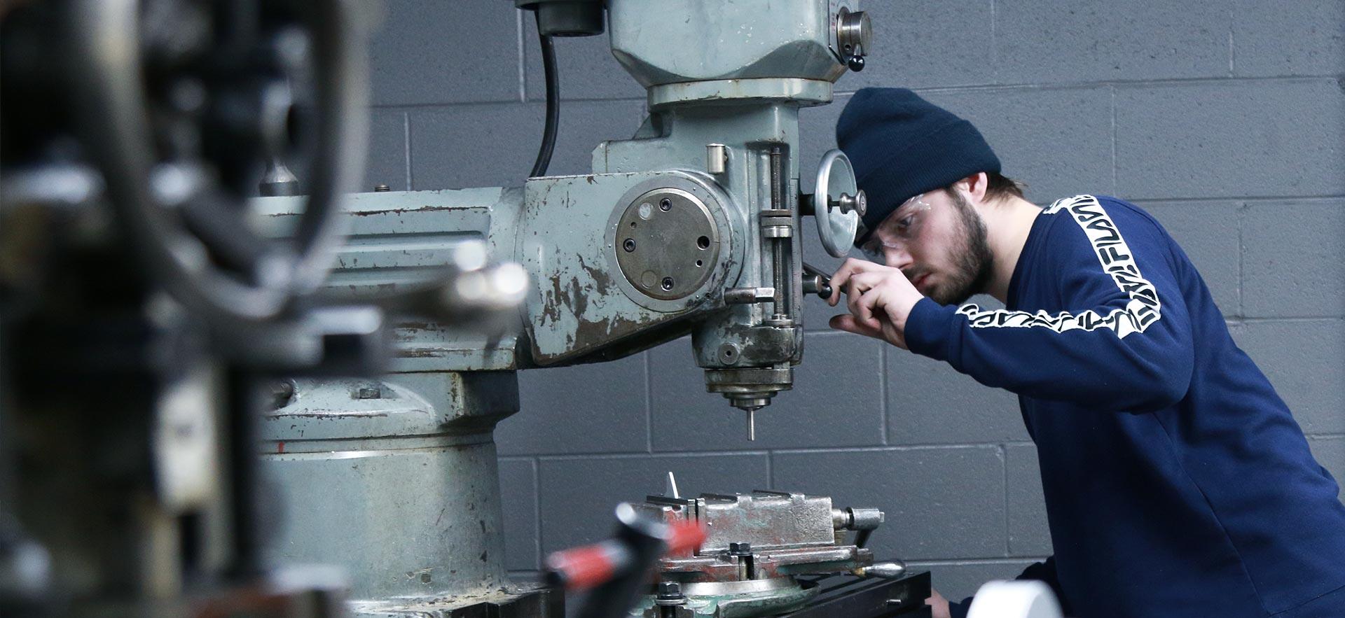 One male machine shop student working on a class project.