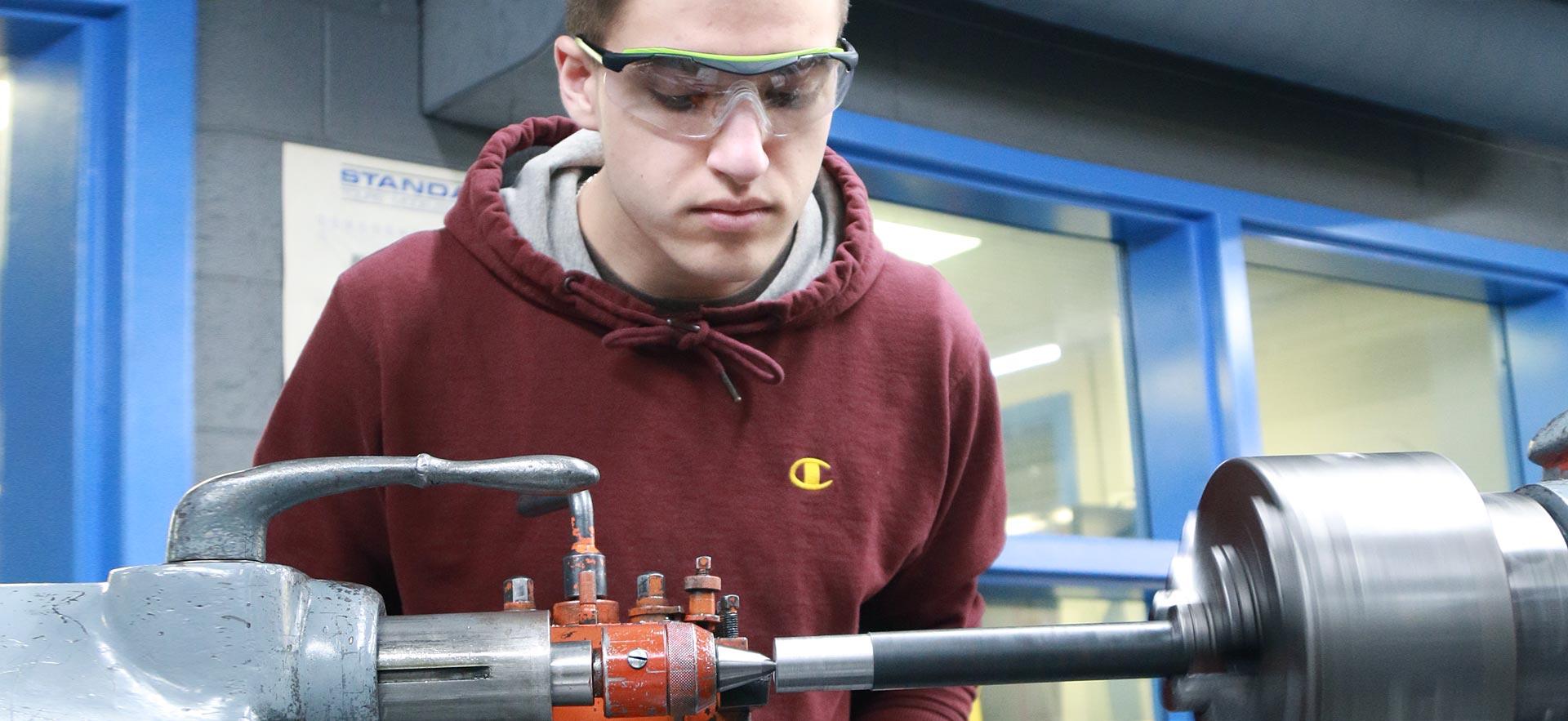 One male machine shop student working on a class project.