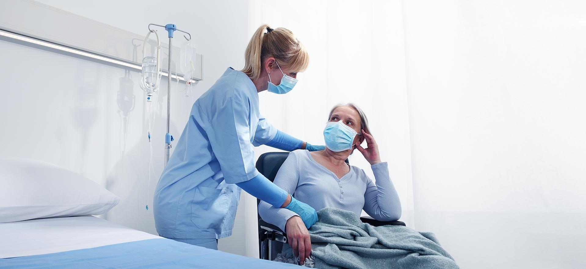 Elderly female receiving palliative care by a female nurse.