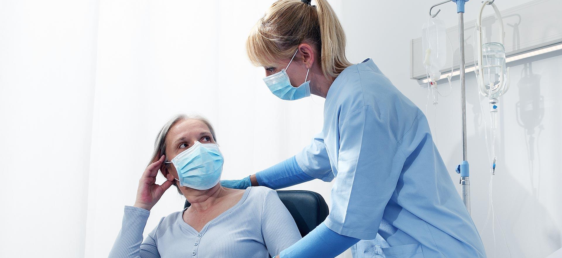 Female perioperative nurse discusses operation with patient.