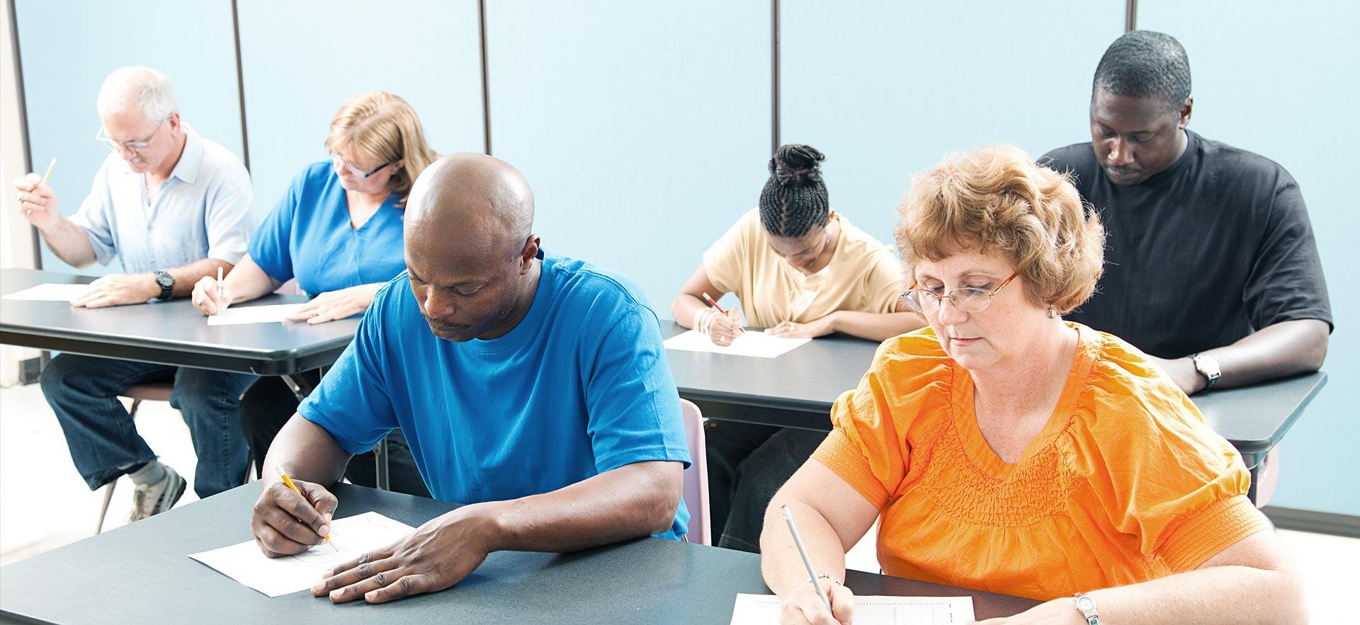 Class of adult learners writing a test.