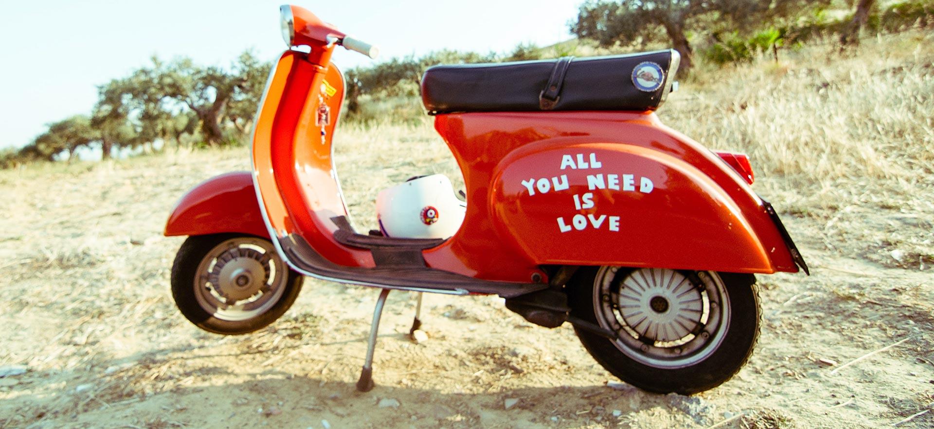 Parked vespa on sand.