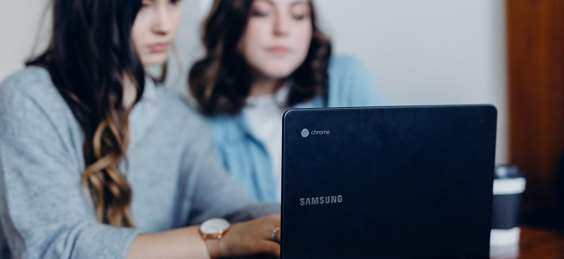 Two female students at a computer.