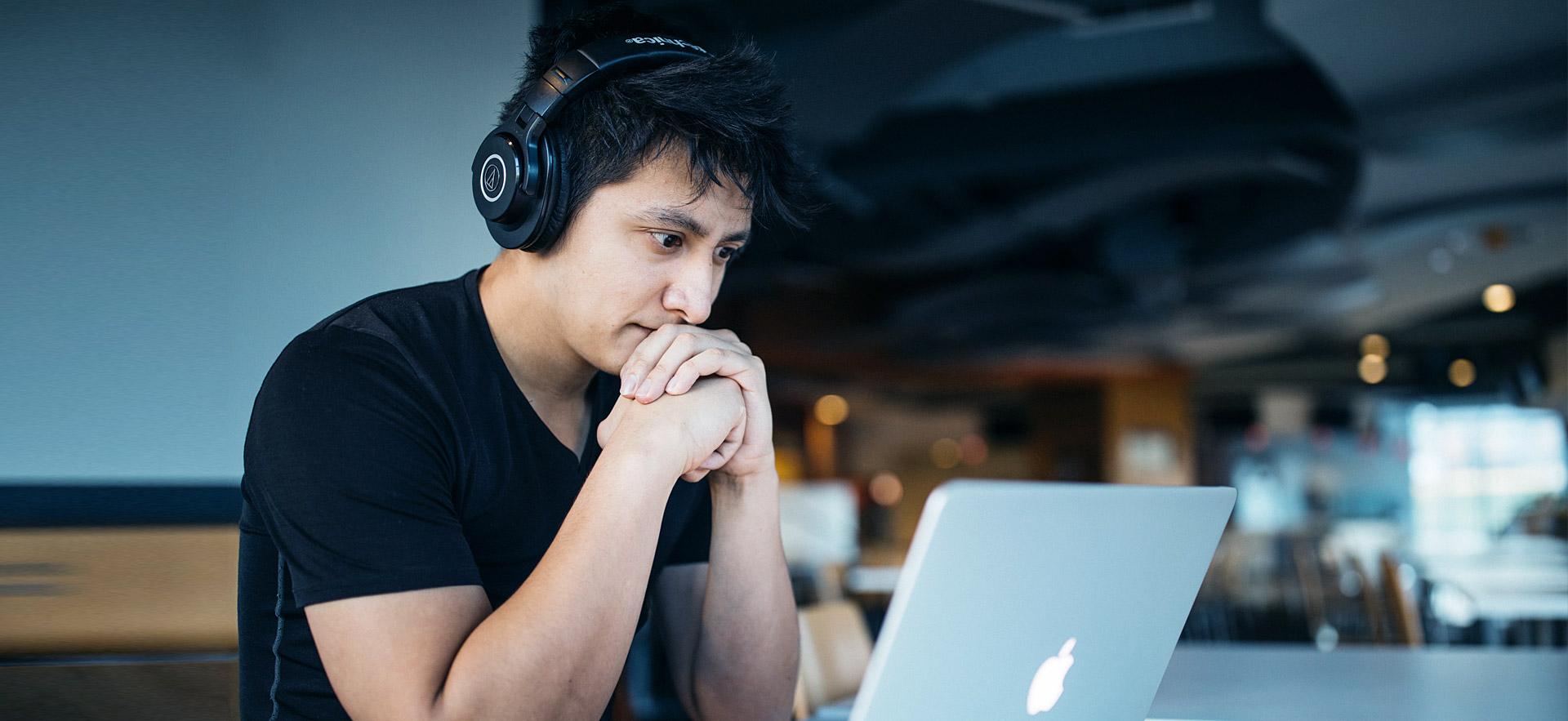 Male student at computer thinking.