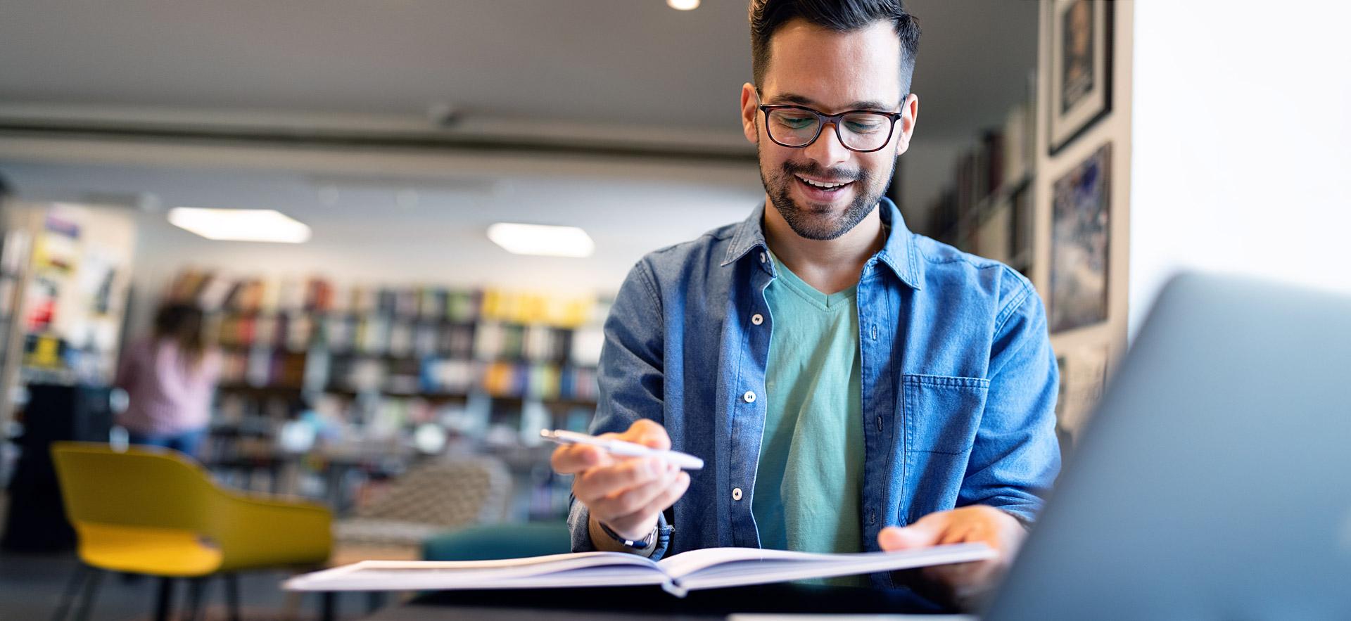 Male student marking up book report.