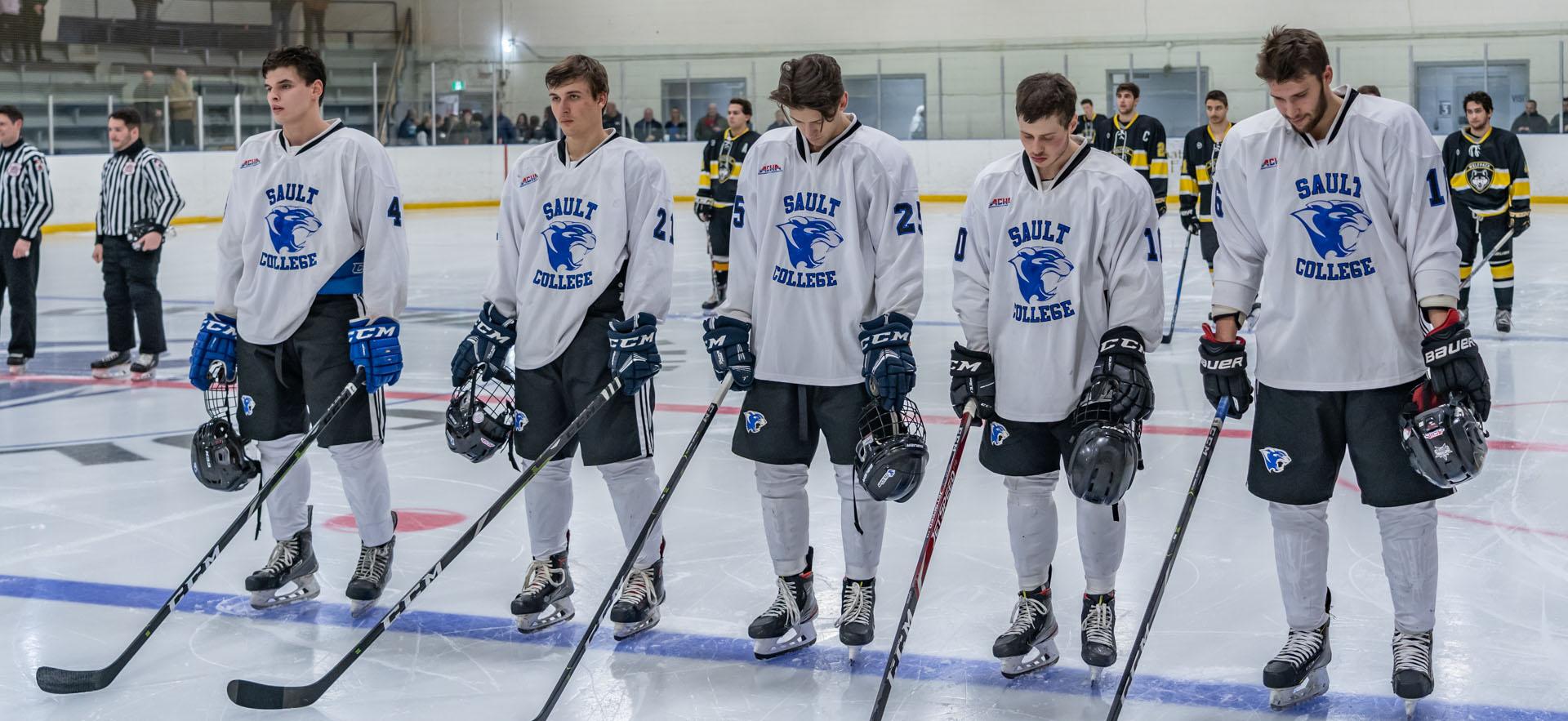 Hockey players lined up at blue line