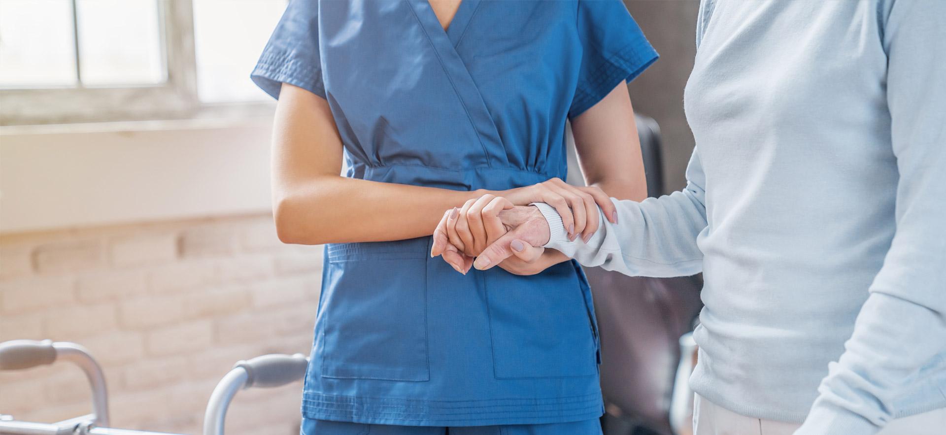 Female nurse helping elderly woman.