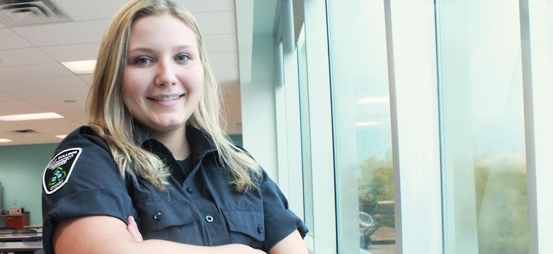 student standing by windows dressed in security uniform