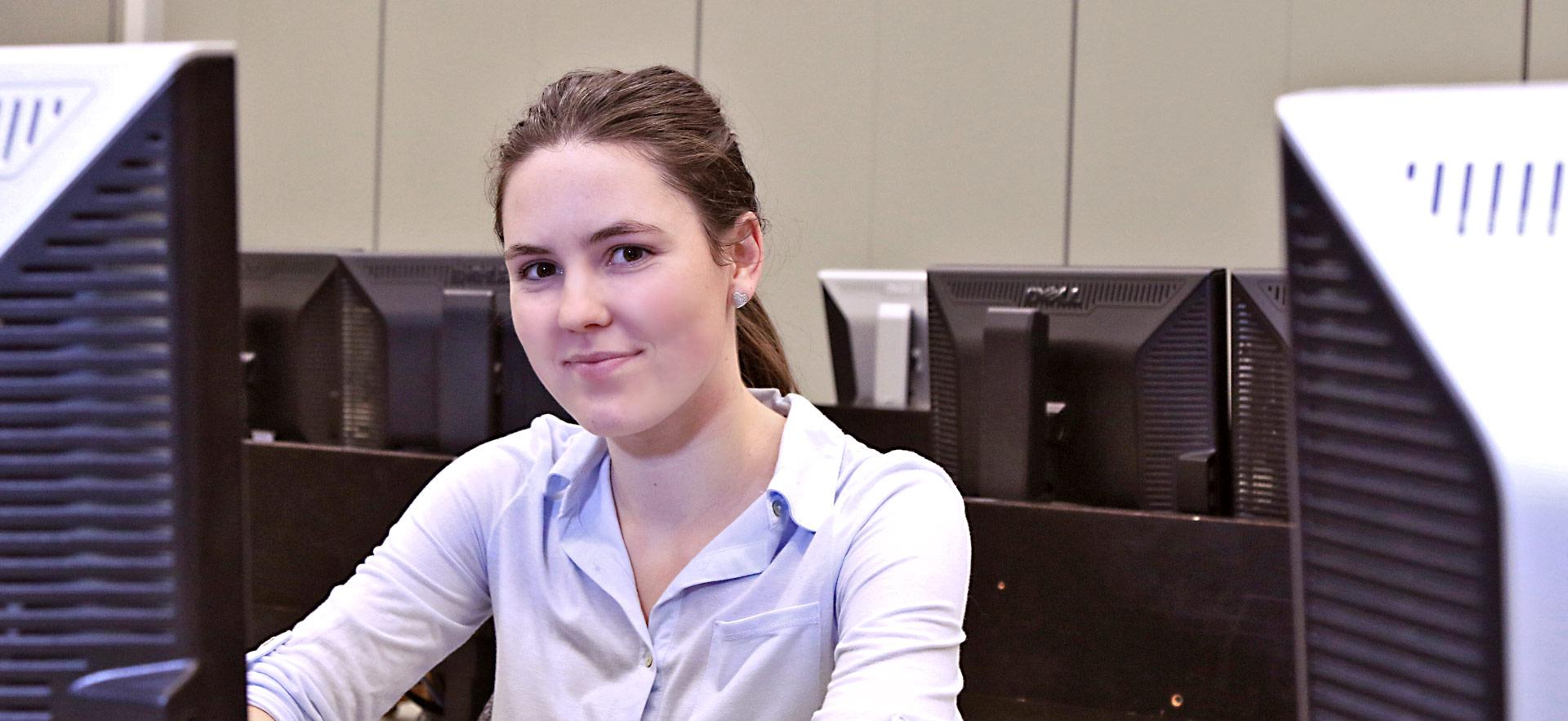 female student in class room with computers in background