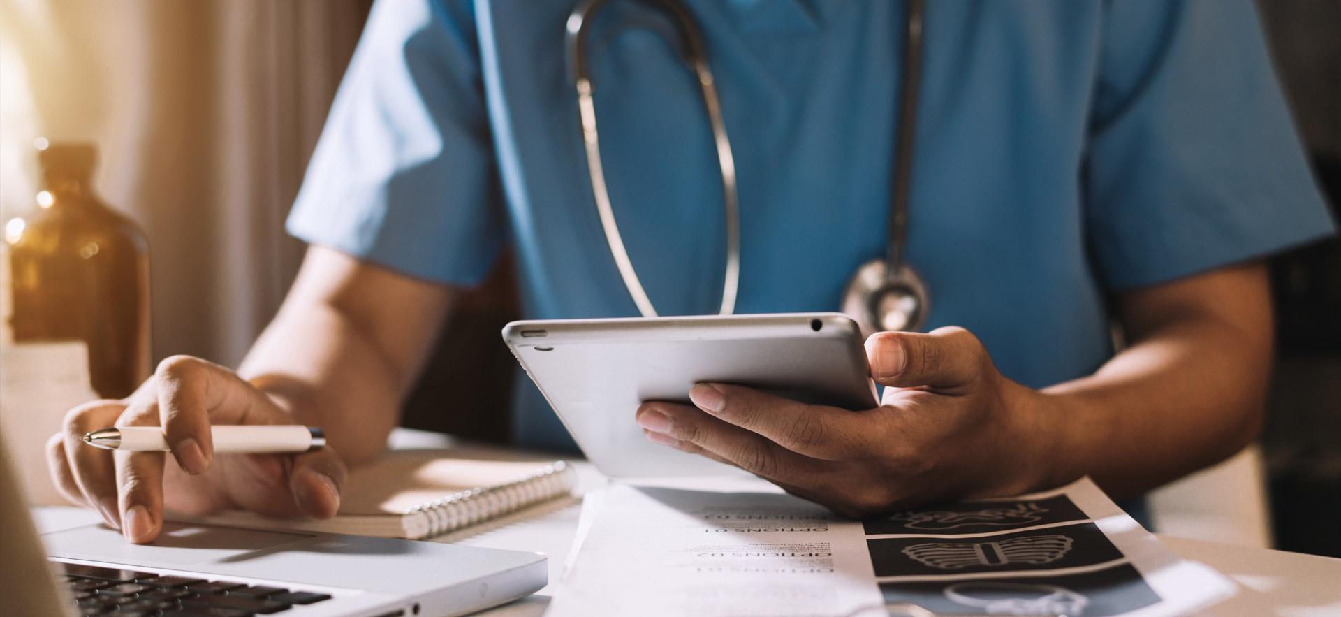 Male nurse reviews medical information on computers.