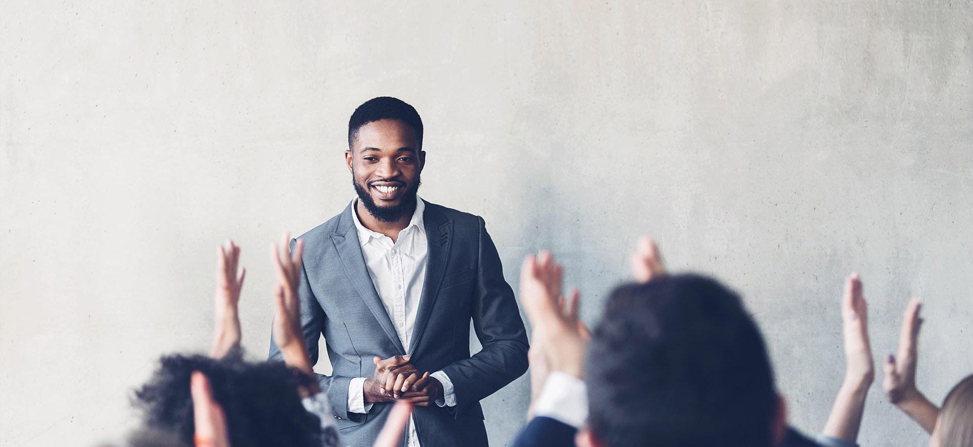 A male manager conducts a presentation in a boardroom.