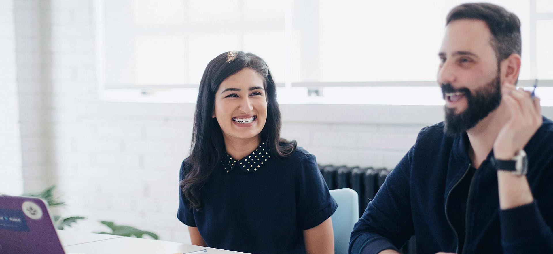 A female legal office assistant smiles during meeting.