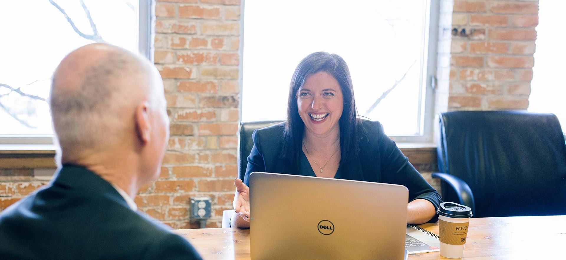 Female office assistant smiling during a meeting.