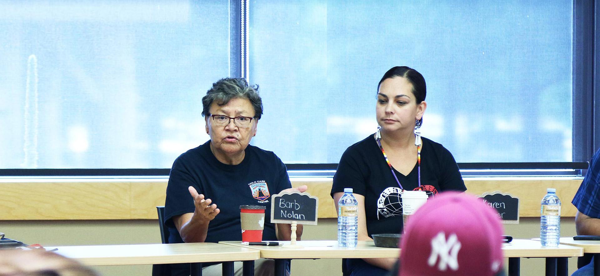 Two female Sault College Indigenous women conduct a group meeting with Indigenous youth.