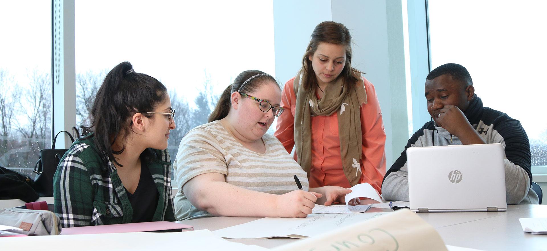 group of students gathered around desk