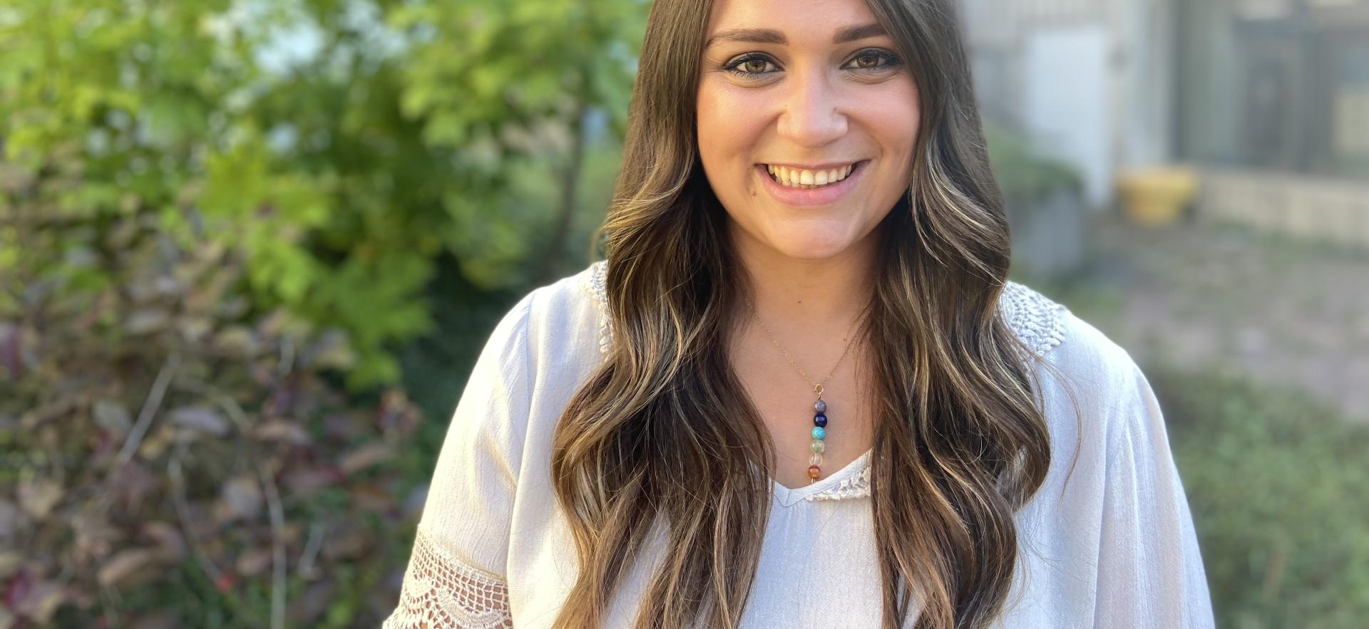 Carly a recruiter posing and smiling in an outdoor setting on campus
