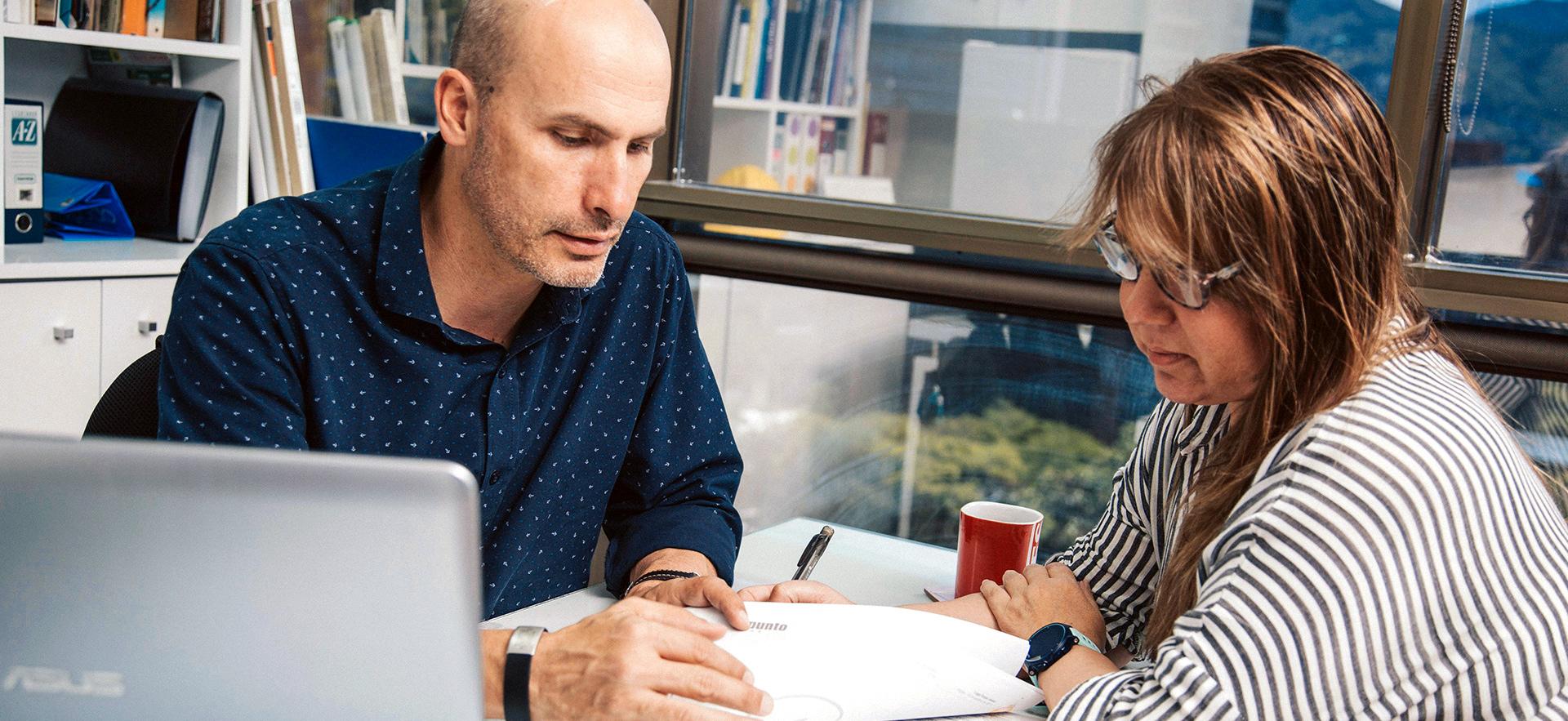 Two people in front of computer have a conversation