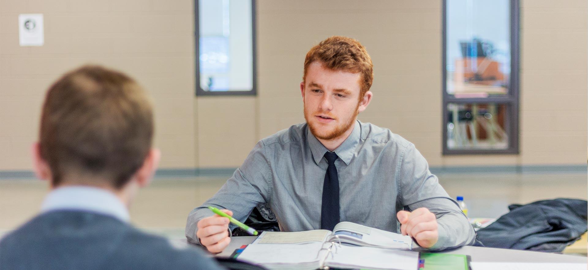 Two male business students discussing a project.