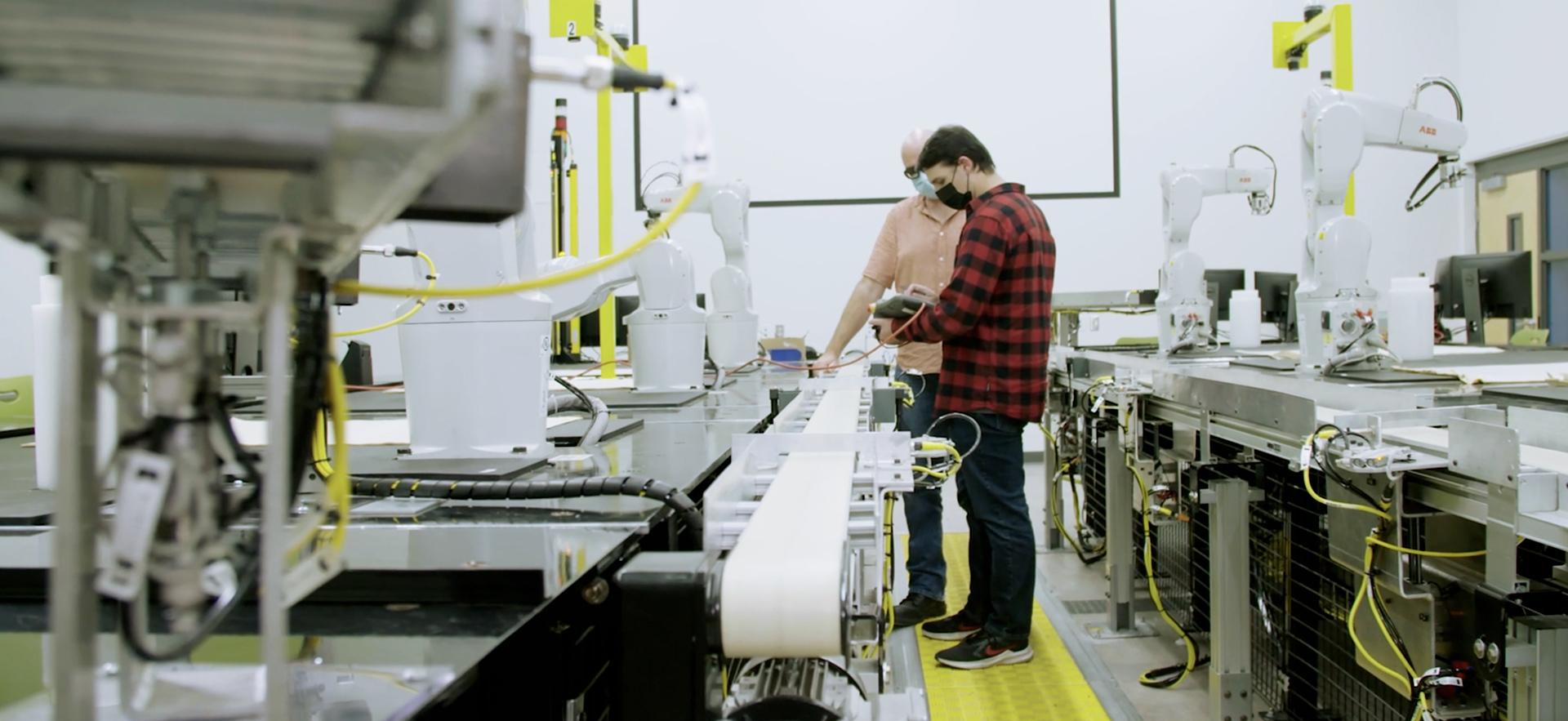 Male student and instructor in a mechatronics class.