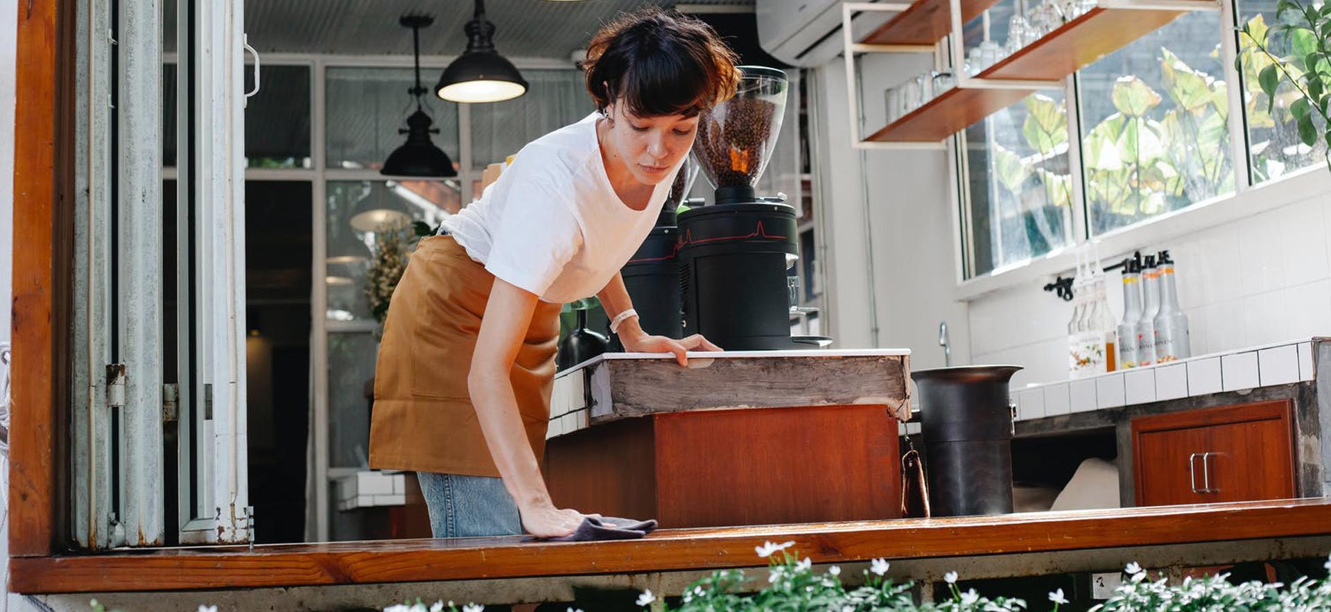 young woman cleaning up at restaurant cafe