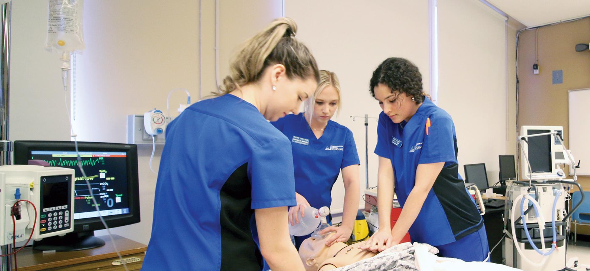 Nursing students work on a doll