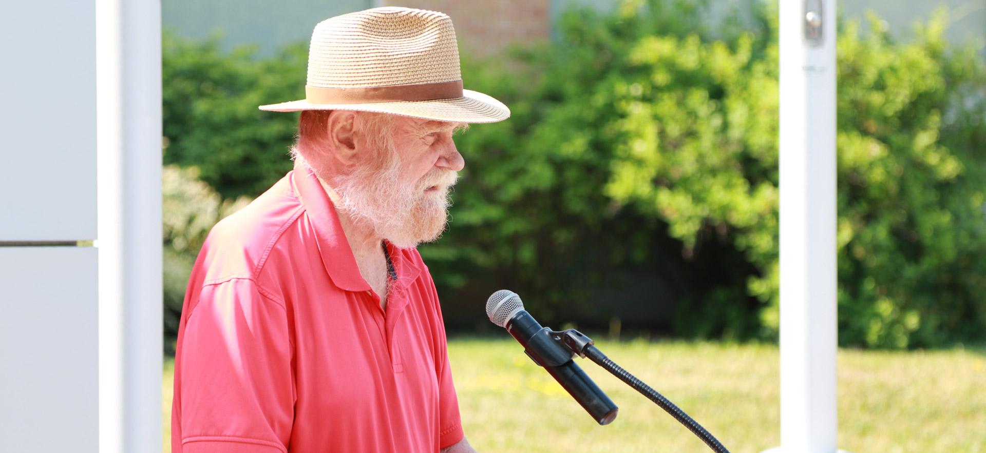 president of sault college with red shirt speaking at a podium 