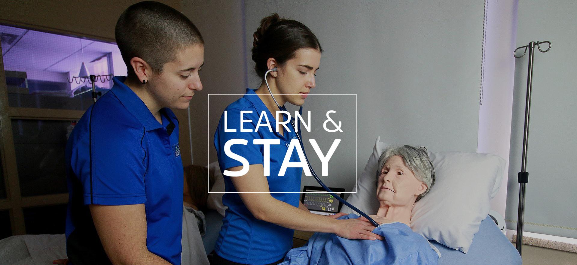 Two nurses in medical simulation lab examining simulated patient