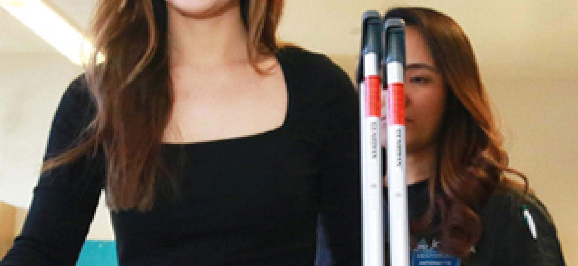 A student in the Occupational Therapist Assistant and Physiotherapist Assistant program teaches someone to use the stairs with crutches