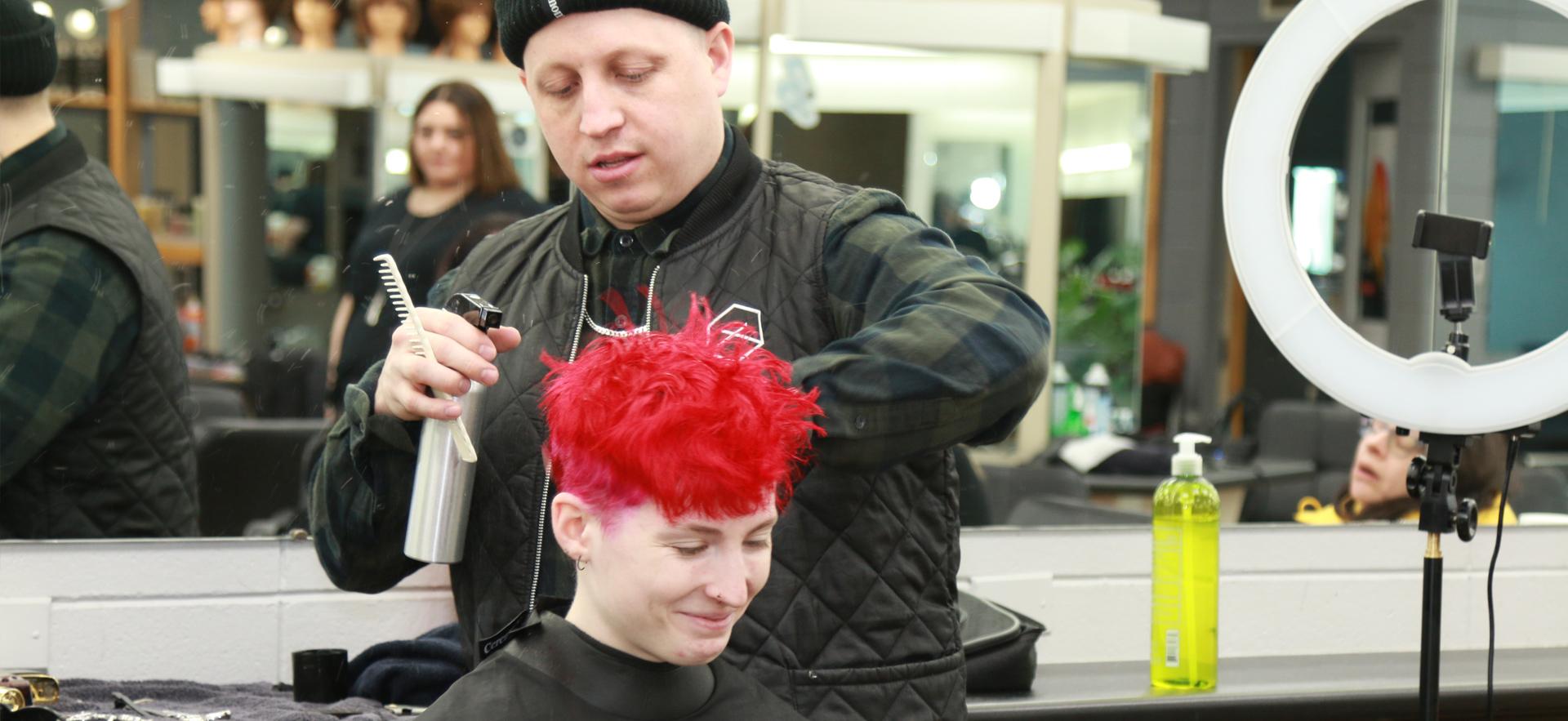 Peter Gosling of Glassbox Education doing a student's hair to teach short hairstyle techniques in his workshop