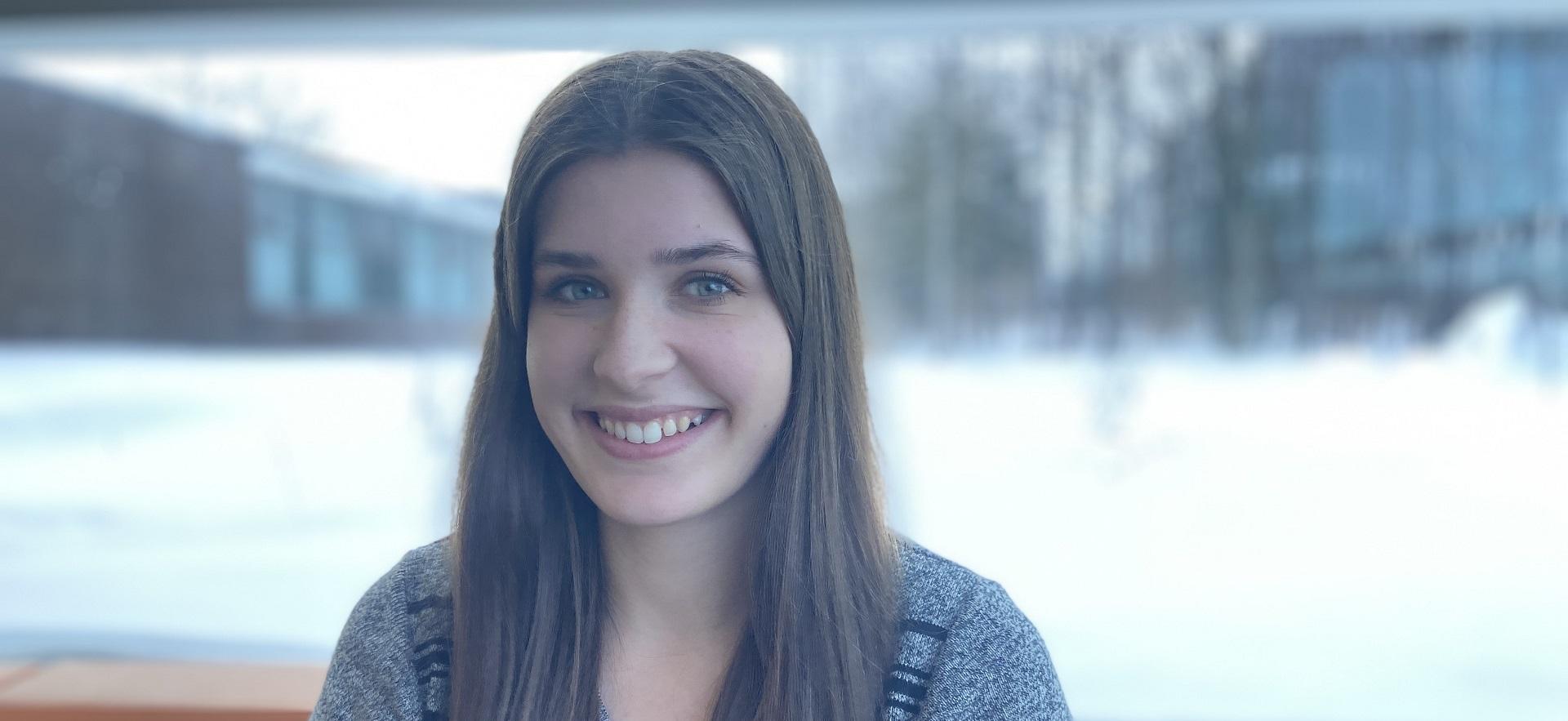 Seanna student ambassador for School of Natural Environment smiling for camera sitting in front of window