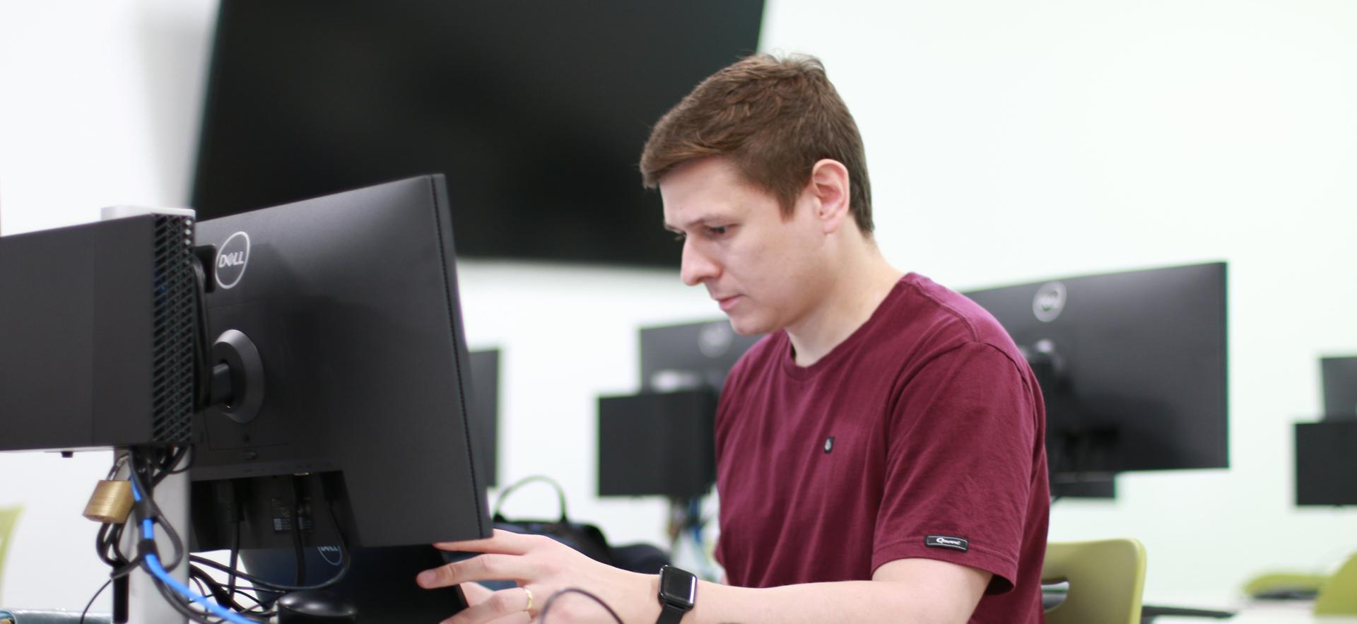 Business - Accounting student on computer in computer lab helping a student at the free Tax Clinics