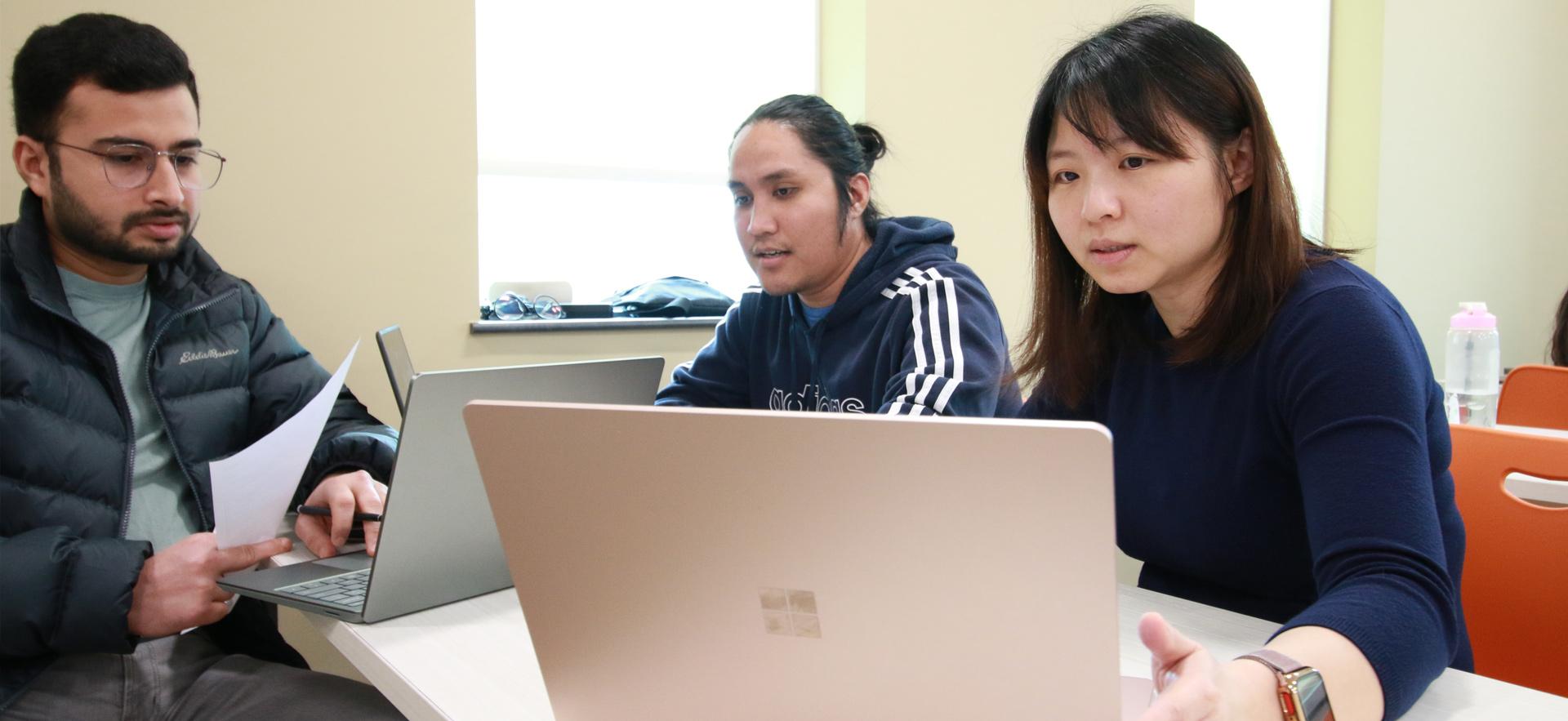 Business - Accounting students on computers in class helping a student at the Tax Clinic