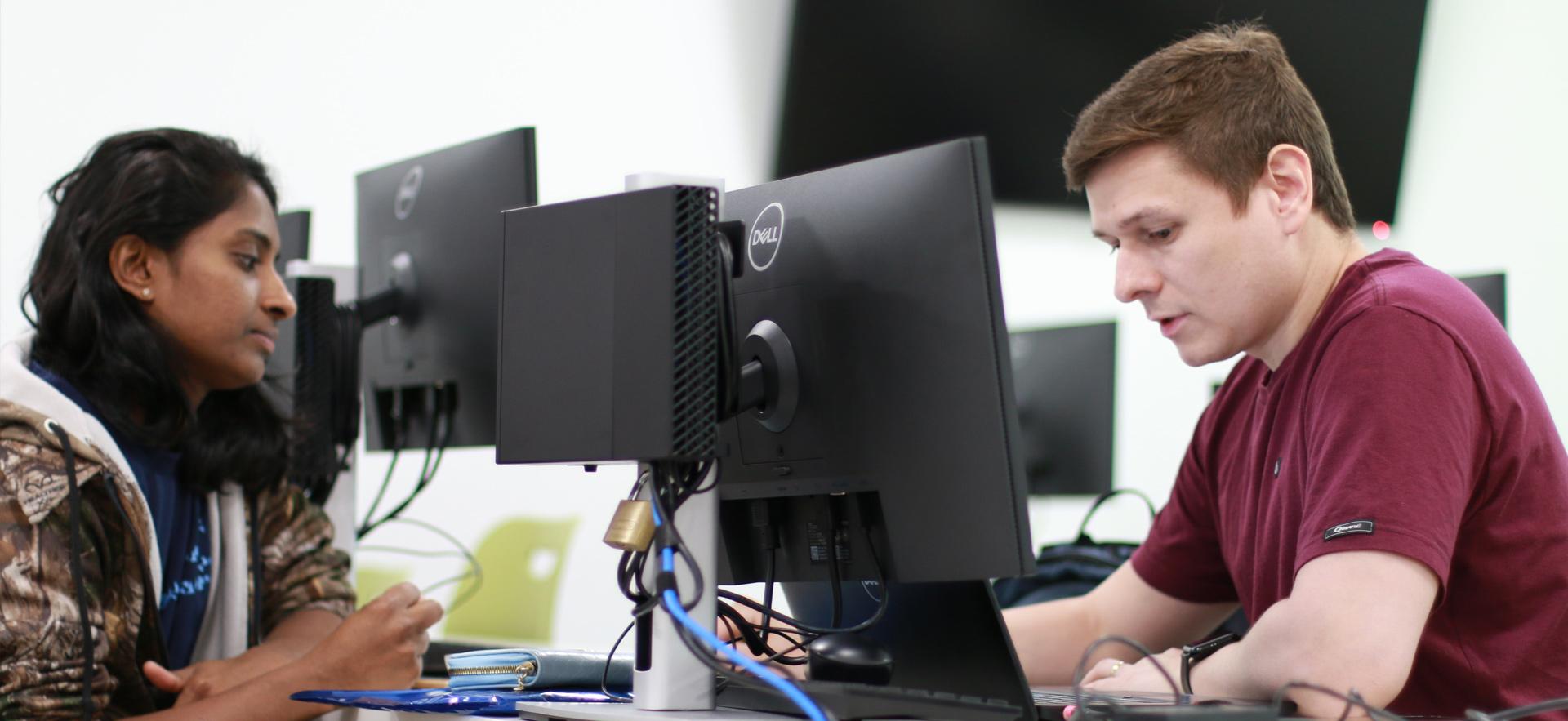 Business - Accounting student on computer in class helping a student at the Tax Clinic